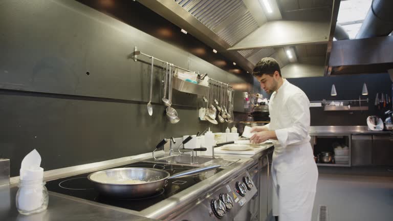 istockphoto-1447964250-640×640 A chef is preparing food in the restaurant's kitchen. Selective focus on a pan on the stove.